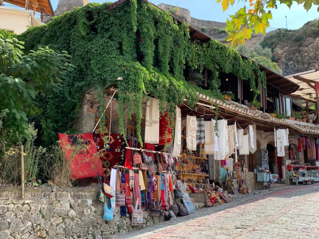 Una fotografia che cattura una fila di negozi caratteristici situati su una strada lastricata a Krujë, offrendo un assaggio dell'atmosfera storica e culturale della città di Durazzo.