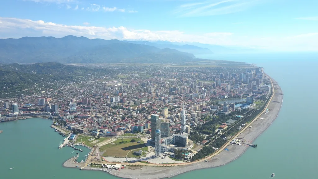 Una fotografia aerea scattata con un drone che mostra la splendida vista della città e della costa di Batumi, unendo architettura moderna e bellezza naturale.