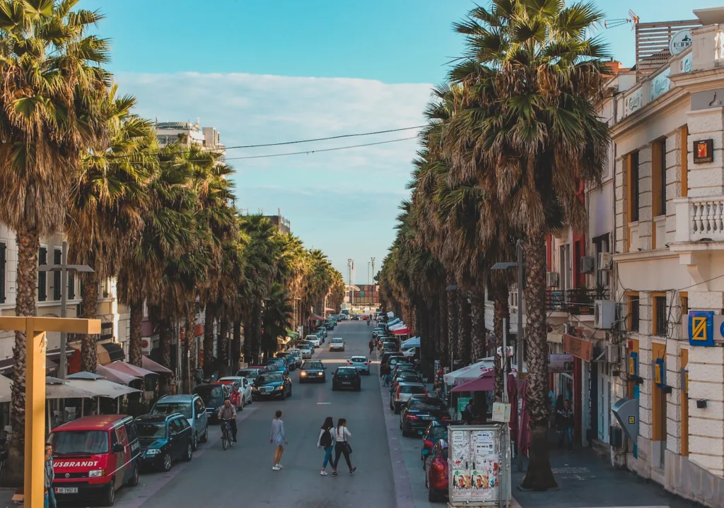 Una fotografia vivida del Boulevard Epidamn, la strada principale della città di Durres, Albania, che mostra l'effervescenza urbana e l'architettura caratteristica della zona.
